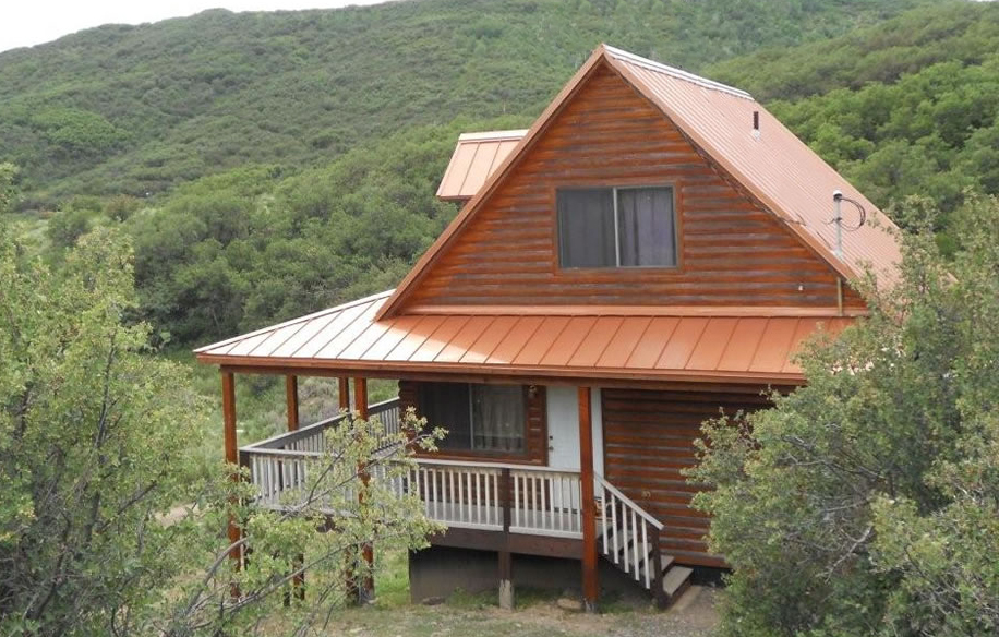 Metal roofing panels are combined with logs to create a rustic-modern fusion. 